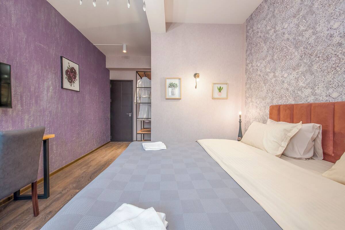 Een moderne slaapkamer met een bed, bureau en garderobekast.