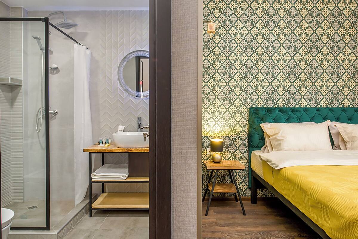Een badkamer met een glazen douchecabine, een wastafel met spiegel en een meubel met planken.