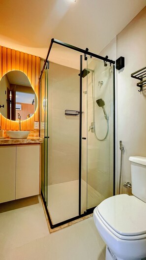 A modern bathroom with a glass-enclosed shower, a white sink, and a toilet. - Setai Aquamaris Vista Mar - By Almare (João Pessoa)