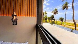 A room with a view of a beach, a wooden slatted wall, and a black decorative light fixture. - Setai Aquamaris Vista Mar - By Almare (João Pessoa)