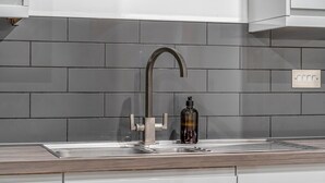 A modern kitchen with a stainless steel sink, a faucet, and a soap dispenser. - The Azure Hideaway 2BR 2BA City Centre (Leicester)