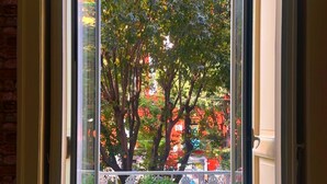 An open sliding glass door leading to an outdoor patio with a table and chairs. - هوستيل دولشي دي مونيكا نابوليتنا (Napoli)