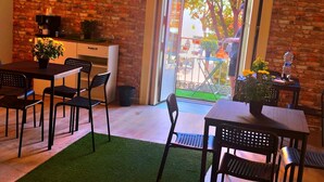 A modern dining area with a brick wall, a large window, and a welcome mat. - هوستيل دولشي دي مونيكا نابوليتنا (Napoli)