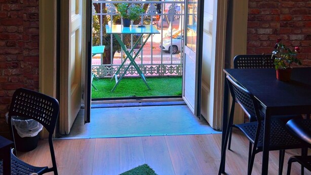 A room with a view of a green lawn and trees through a glass door. - هوستيل دولشي دي مونيكا نابوليتنا (Napoli)