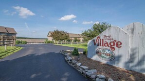 Een bord voor Deep Creek Village, met een duidelijke weg naar een gebouwencomplex.