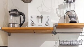 A kitchen with a coffee maker, a kettle, a blender, and a hanging light fixture. - Charming Pied-e-terre near the beach for a relaxing getaway (Los Angeles)