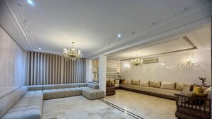 Un salón amplio con un sofá seccional grande, una chaise lounge y una pequeña mesa de madera.
