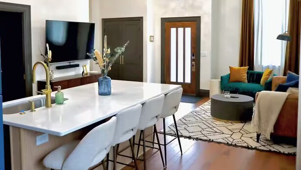 A modern living space with a kitchen, dining area, and seating area.