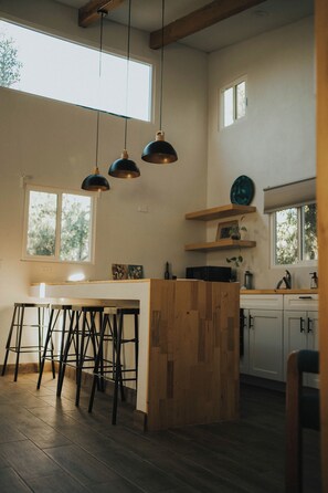 Cabaña Deluxe, patio, vista al jardín | Cocina privada | Refrigerador, microondas y utensilios de cocina 