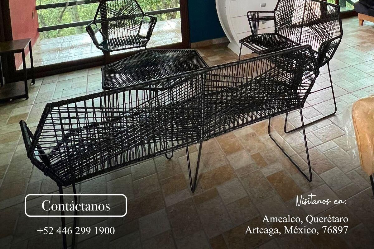 A modern interior with black metal furniture, large windows offering a view of greenery, and contact information for Rancho Paraíso Real.