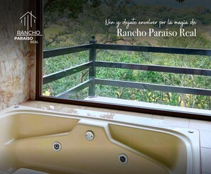 Ein Badezimmer mit einer Badewanne und Blick auf Grünfläche.