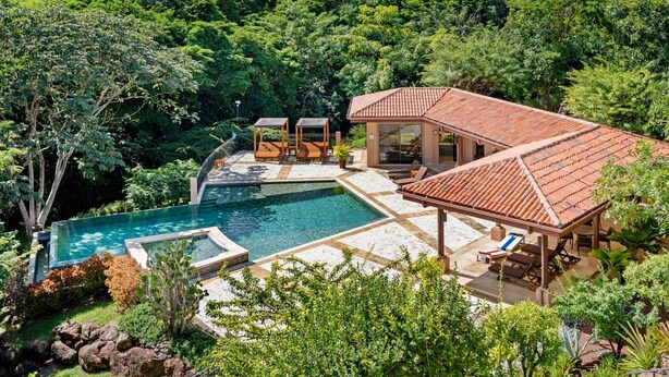 A luxurious villa with a swimming pool, outdoor seating, and a lush garden. - Treetop Ocean View Penthouse - Jobo 15 (Brasilito)