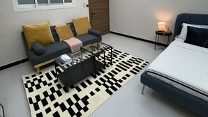Una camera da letto moderna con un letto, un divano, un tavolino da caffè e un tappeto.