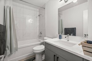 Une salle de bain moderne avec une baignoire, des toilettes et un lavabo.