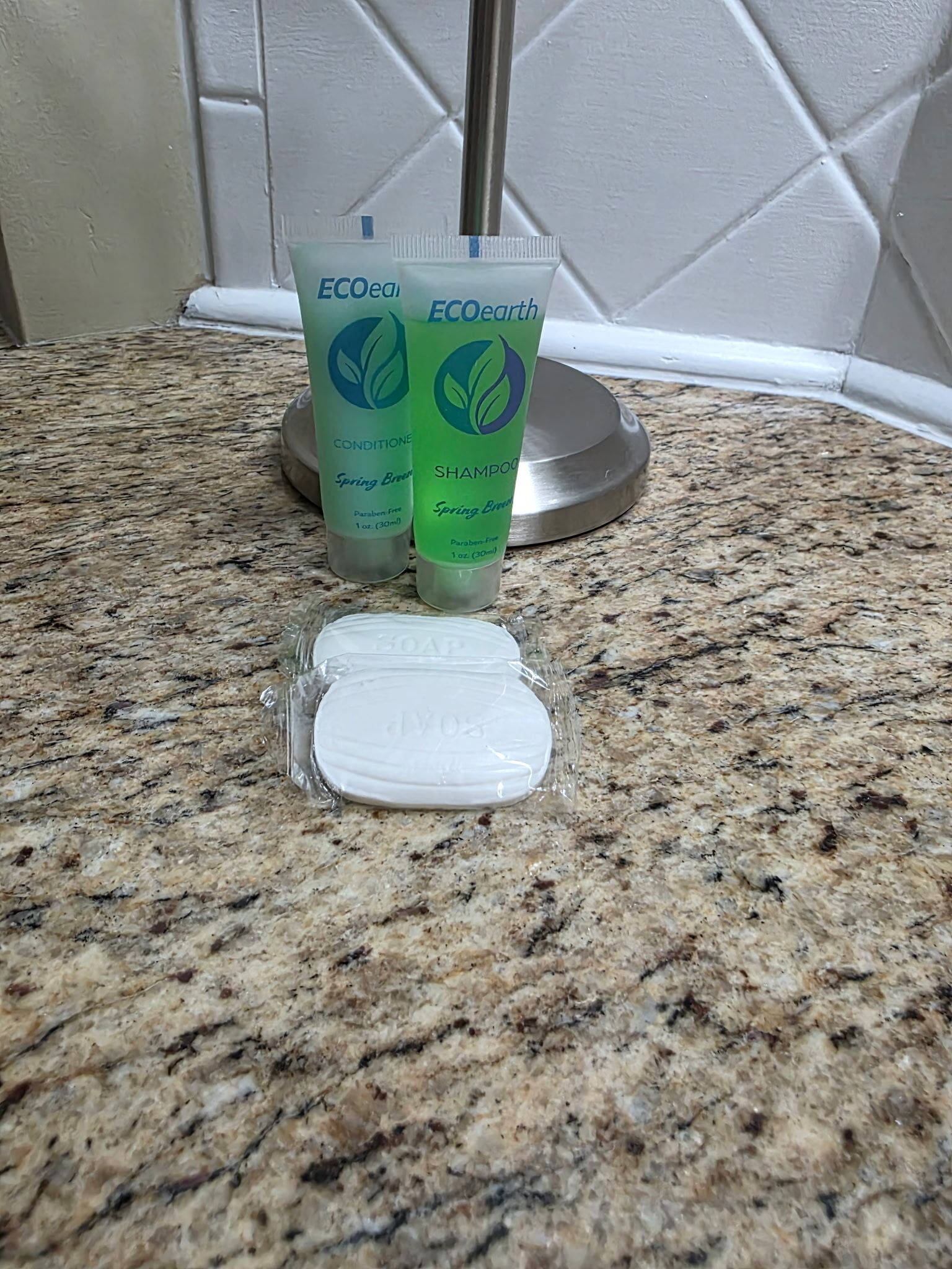 Dos botellas de champú y acondicionador ECOearth Spring Breeze sobre una encimera de granito.