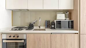Une cuisine moderne équipée d’une cuisinière à gaz, d’un four, d’un four à micro-ondes et d ’une machine à café.