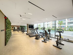 A modern gym with treadmills, elliptical machines, and weight equipment. - The Grove - 411 Studio (Dubai)