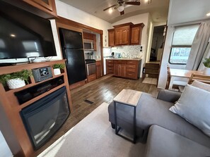 A compact RV kitchen with a built-in oven, microwave, and refrigerator. - SeaGlass Getway - Walk to Beach - 2 Bedrooms - King Bed - Sleeps 6 (North Topsail Beach)