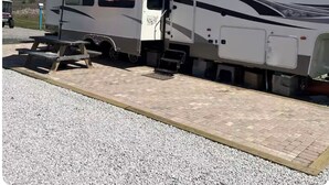 Un camping-car Silverback équipé d’une table de pique-nique et d’un parasol rouge et blanc à rayures.