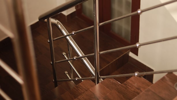 A wooden staircase with metal railings and a glass door at the top. - Fort Verdant Homestay (Kochi)