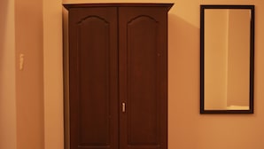 A room with a wooden wardrobe and a mirror on the wall. - Fort Verdant Homestay (Kochi)