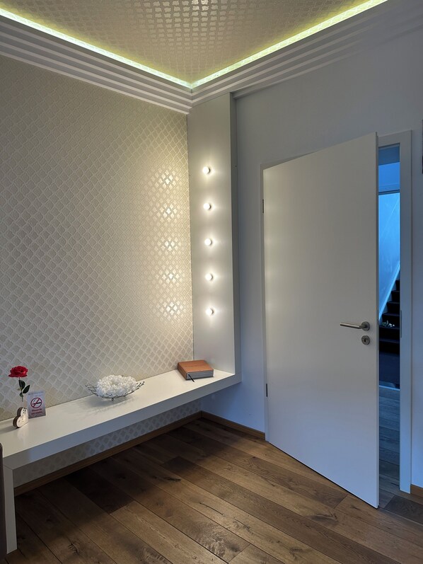 Una habitación moderna con un banco, una puerta y un papel tapiz estampado.