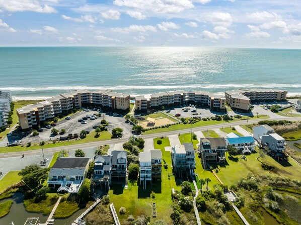 Un hôtel situé sur la côte, composé de plusieurs bâtiments, doté d’un parking et offrant une vue sur l’océan.
