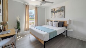 A bedroom with a bed, a desk with a laptop, a globe, a plant, and a ceiling fan. - Relax, Work, Play! Charming 3-bedroom house in amazing Dallas with Game Room (Dallas)