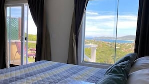A hotel room with a large bed, a view of the outdoors, and a sliding glass door. - Top De Buzios Boutique Hotel & Spa (Búzios)