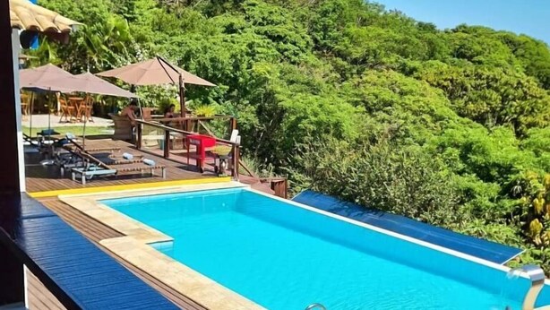 A rectangular swimming pool with a wooden deck and a metal ladder. - Top De Buzios Boutique Hotel & Spa (Búzios)