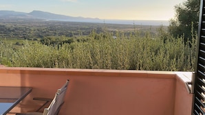 A balcony with a view of a landscape, a table, and chairs. - BouganVilla - Two-room apartment with sea view in Badesi (Badesi)