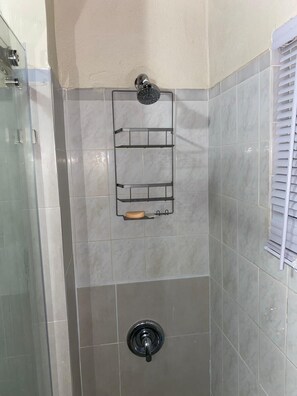 Chuveiro, toalhas de banho, sabonete, papel higiênico