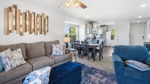 A modern living room with a sofa, ottoman, and a ceiling fan. - Beautiful brand new sister condo's, no steps, located next to Silver Dollar City (Branson)