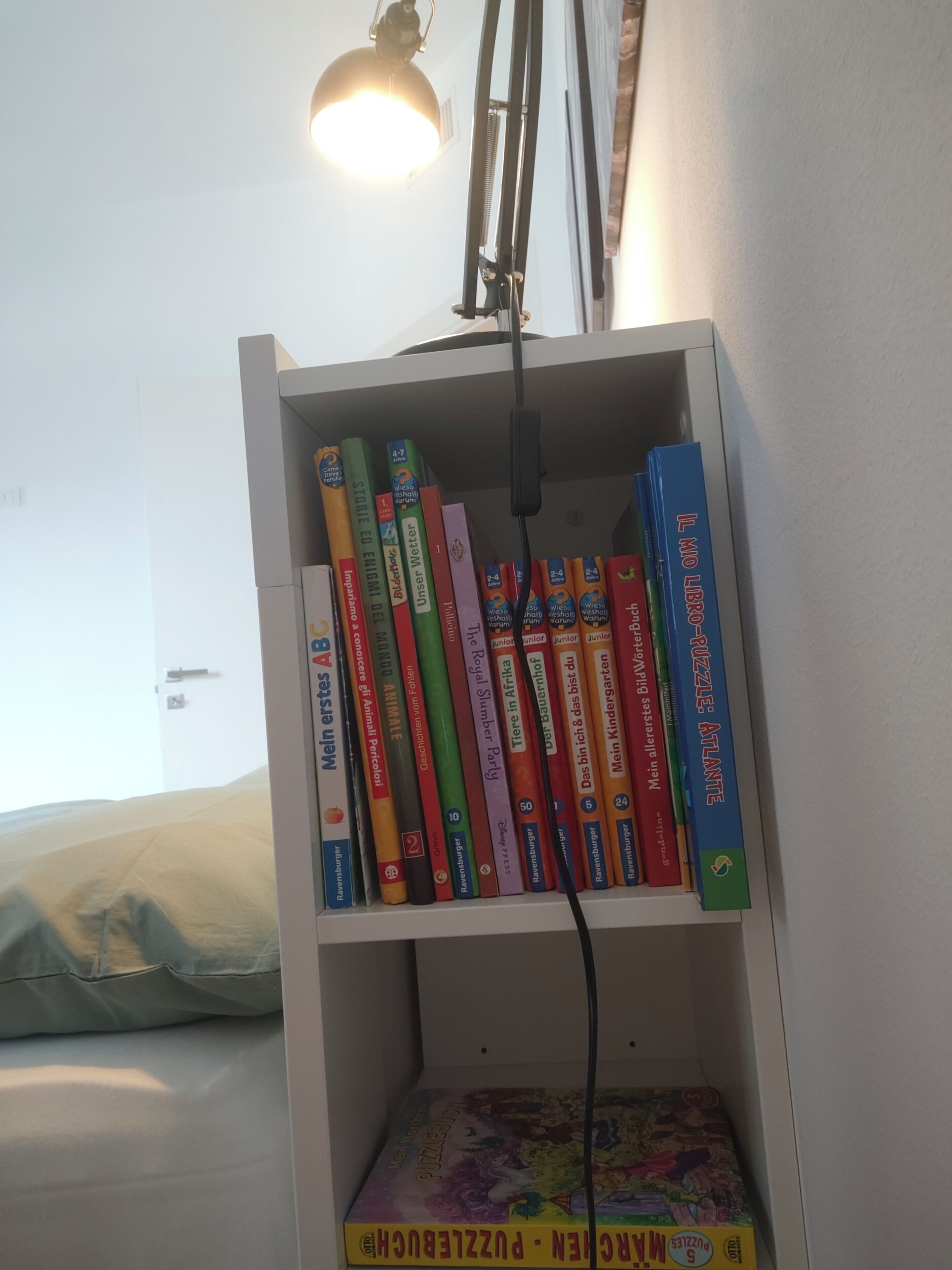 A bookshelf with various books and a puzzle box.