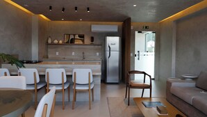 Une cuisine moderne équipée d’un réfrigérateur, de chaises de salle à manger, d’un canapé et d’une table basse.