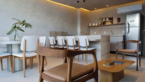 Une cuisine moderne avec des chaises blanches, une table à manger en bois et une table basse.