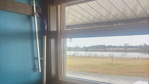 A room with a window, a mop leaning against the wall, and a wooden floor. - 3 Pines Private Lake Home (Warner)