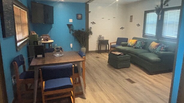 Un espacio habitable compacto con zona de comedor, sofá y una pequeña mesa.