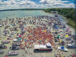 Une vaste zone extérieure où de nombreux bateaux sont amarrés en cercle, entourés d’une foule de personnes.