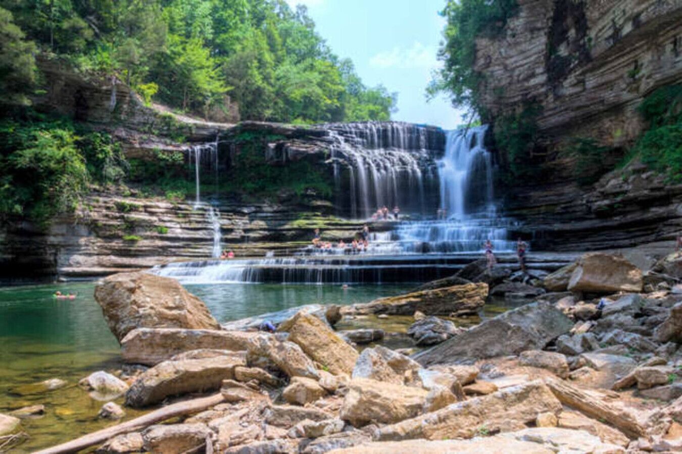 Een natuurlijke waterval met rotsachtig terrein en helder water.