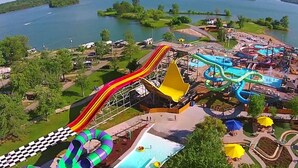 Ein Wasserpark mit zahlreichen Rutschen und Pools, umgeben von viel Grün und einem See.