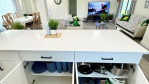 A modern kitchen with a central island, built-in cabinets, and a dining area with a wooden table and chairs.