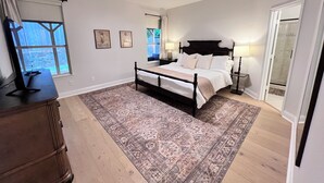A bedroom with a bed, a ceiling fan, a window, a nightstand, and a dresser. - Spacious Roanoke Retreat (Roanoke)
