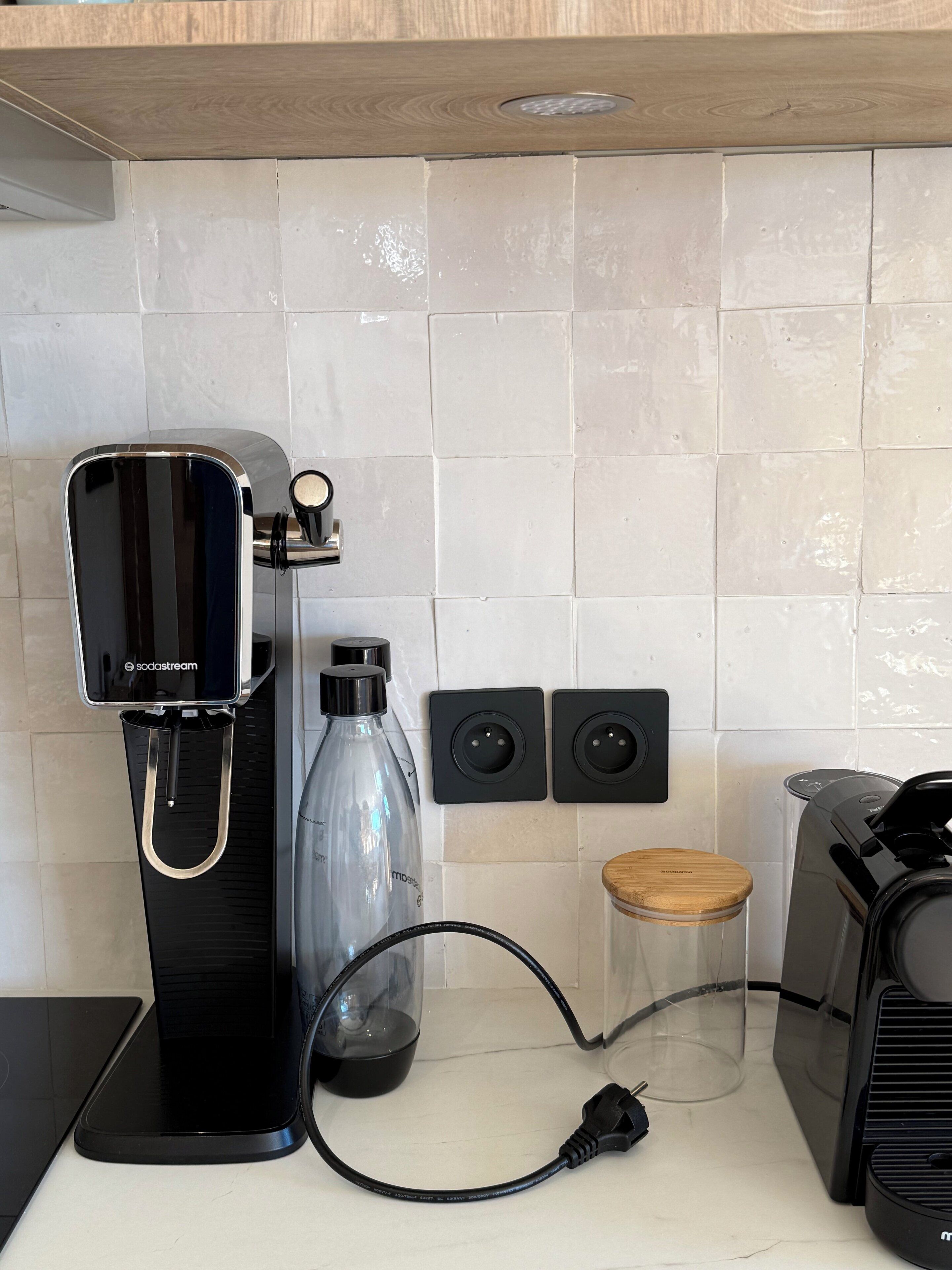 Ett kök med en kaffemaskin, en vattenautomat och en brödrost.