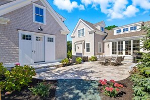 A residential property with a covered patio, a swimming pool, and a landscaped garden.