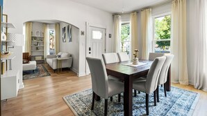 Un'area pranzo moderna con un tavolo di legno, sei sedie e una ventola a soffitto.