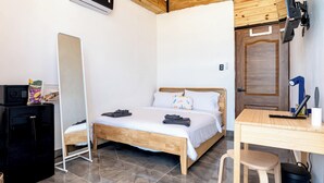 A bedroom with a bed, a desk, a chair, a mirror, a wardrobe, and a small kitchenette. - Bright Room with Private Bathroom & Balcony Ocean View (San Felipe)