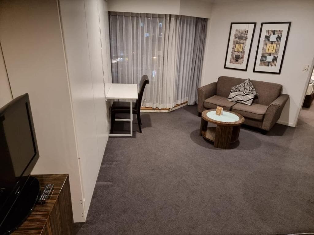 Un salon comprenant un canapé, une table basse, un téléviseur et un coin repas avec une chaise et une table.