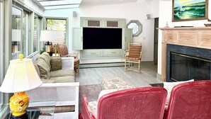 A living room with a TV, a fireplace, and a large window. - Rehoboth Beach House Dog OK Hot Tub Sleeps 12 Clean and Convient (Rehoboth Beach)