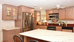 A kitchen with wooden cabinets, stainless steel appliances, and a large island. - Rehoboth Beach House Dog OK Hot Tub Sleeps 12 Clean and Convient (Rehoboth Beach)